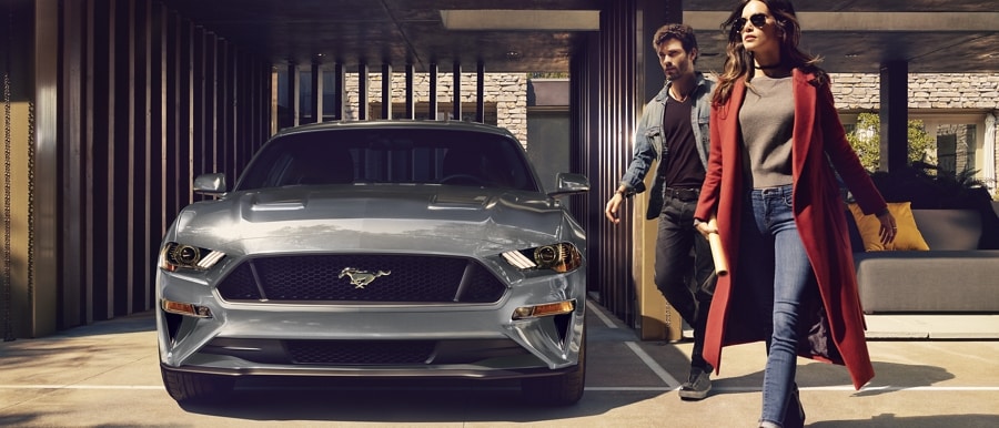 2023 Ford Mustang® 2.3L High-Performance Package in Iconic Silver Metallic parked in a garage with two people walking past