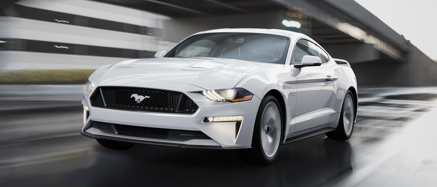 2023 Ford Mustang® coupe in Oxford White being driven down a street