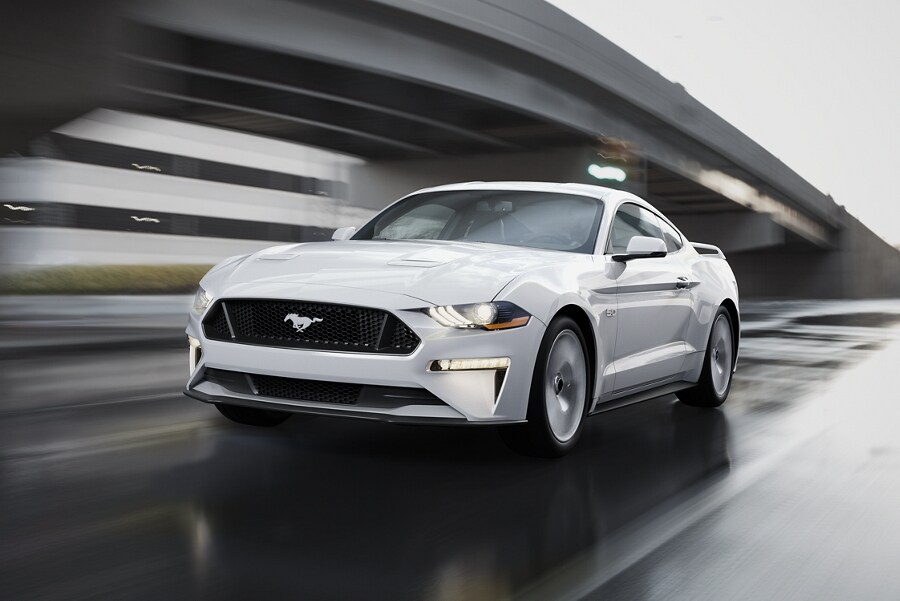 2023 Ford Mustang® coupe in Oxford White being driven down a street