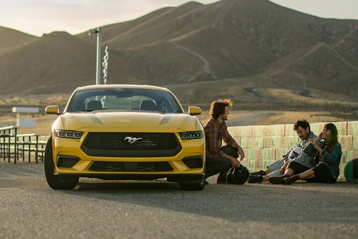 2024 Ford Mustang® EcoBoost® coupe in Yellow Splash Metallic Tri-coat (extra-cost paint) parked near people