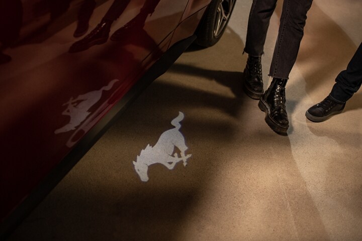 People approaching a 2024 Ford Mustang® GT Premium model with approach detection welcome exterior lighting