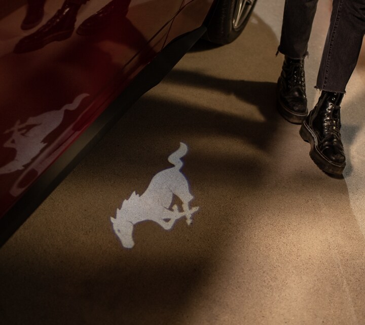 People approaching a 2024 Ford Mustang® GT Premium model with approach detection welcome exterior lighting