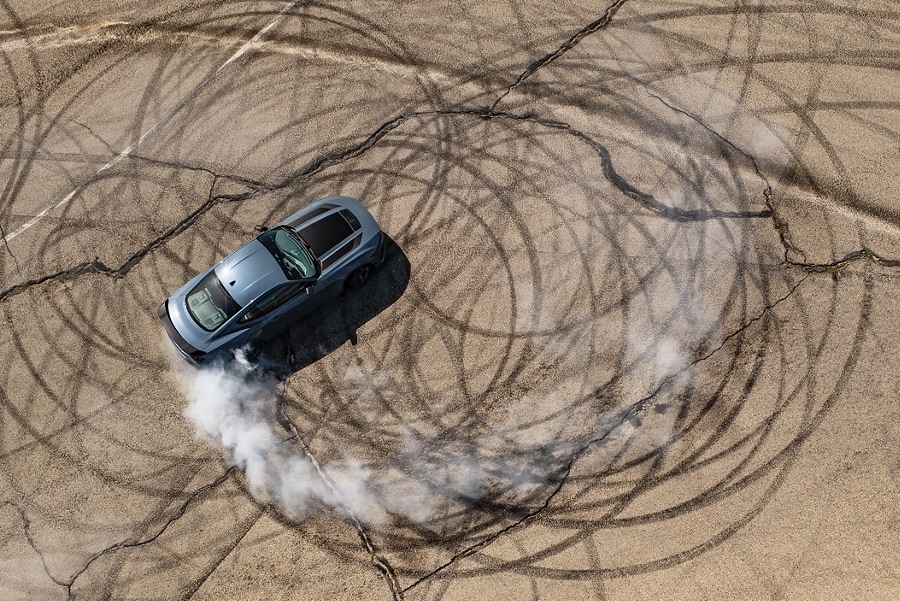 2024 Ford Mustang® coupe with stripes and a driver performing burnouts on a closed course