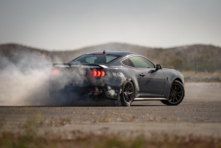 Driver performing a burnout on a closed course in a 2024 Ford Mustang® Dark Horse™ model