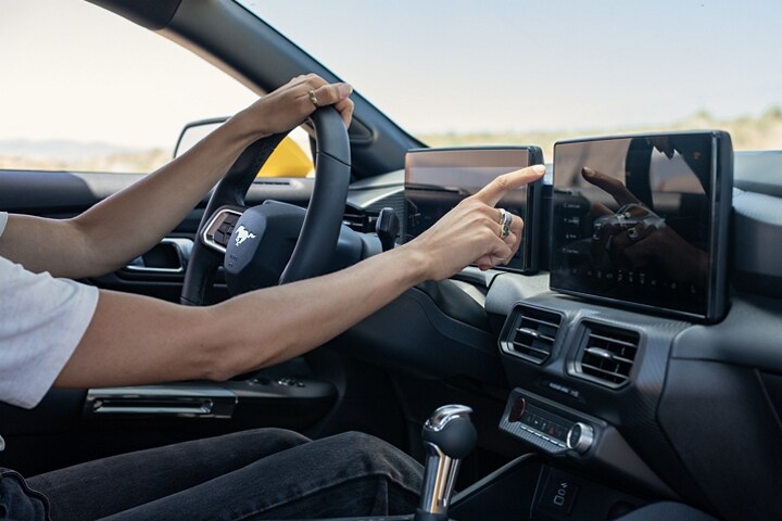 Driver using the 2024 Ford Mustang® touchscreen