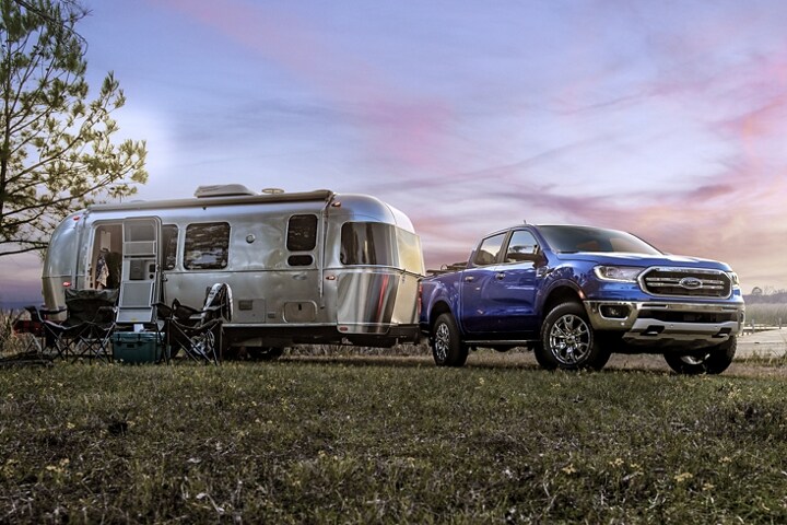 2023 Ford Ranger® in Velocity Blue parked with a camper trailer attached