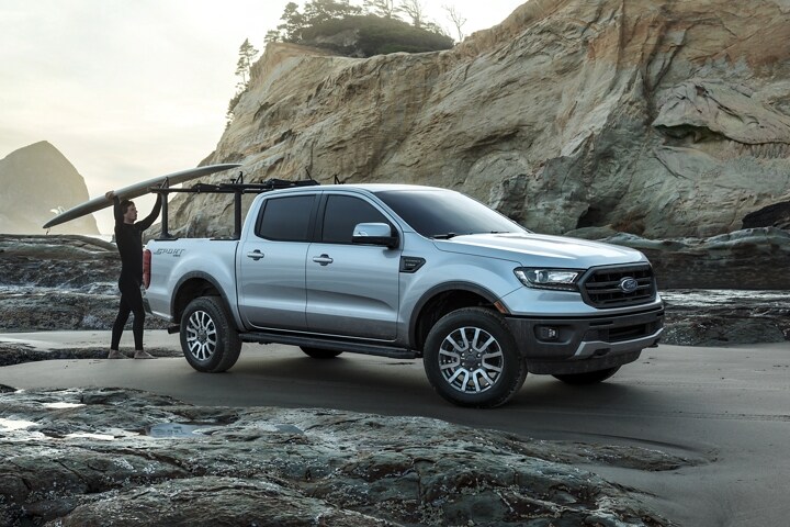 2023 Ford Ranger® at oceanfront with surfer shown with optional bed-mounted rack accessory