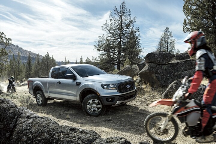 2023 Ford Ranger® being driven off road with dirt bikes to the front and rear