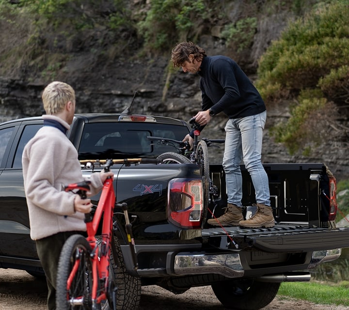 Two people with gear being loaded into the bed of a 2024 Ford Ranger®