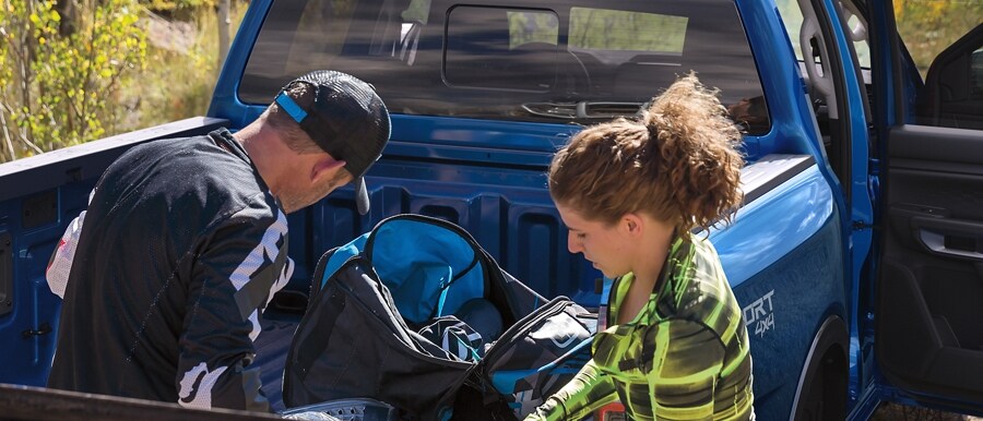 Close-up of two people with gear being loaded near the back of their 2024 Ford Ranger®
