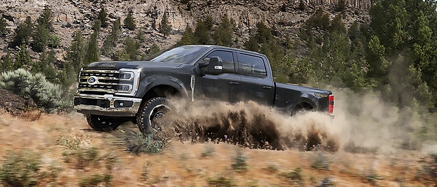 2023 Ford Super Duty® Tremor® kicking up dirt while being driven on a mountain trail