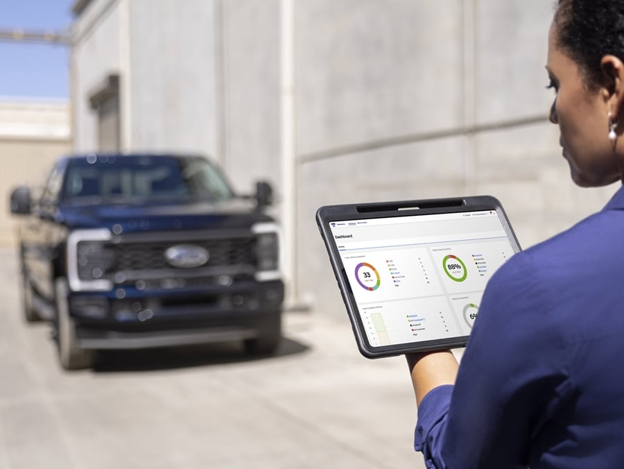 Woman looking at a tablet with a 2025 Ford Super Duty® F-250® XL Appearance Package model in the background