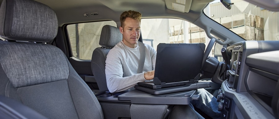 Person working on a laptop computer inside a 2023 Ford Super Duty® F-250 XL pickup