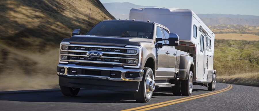 2023 Ford Super Duty® F-350 Lariat pulling a camper on a scenic road