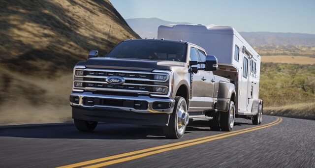 2023 Ford Super Duty® F-350 Lariat pulling a camper on a scenic road