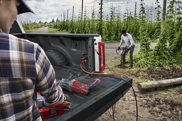 Two people using the Pro Power Onboard feature on a 2023 Ford Super Duty® pickup