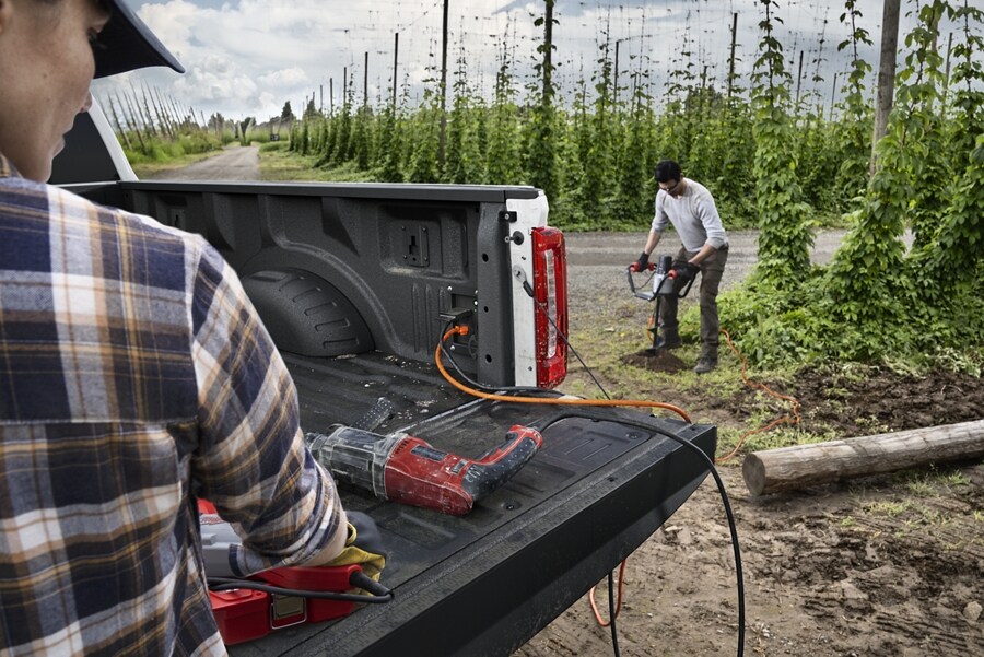 Two people using the Pro Power Onboard feature on a 2023 Ford Super Duty® pickup