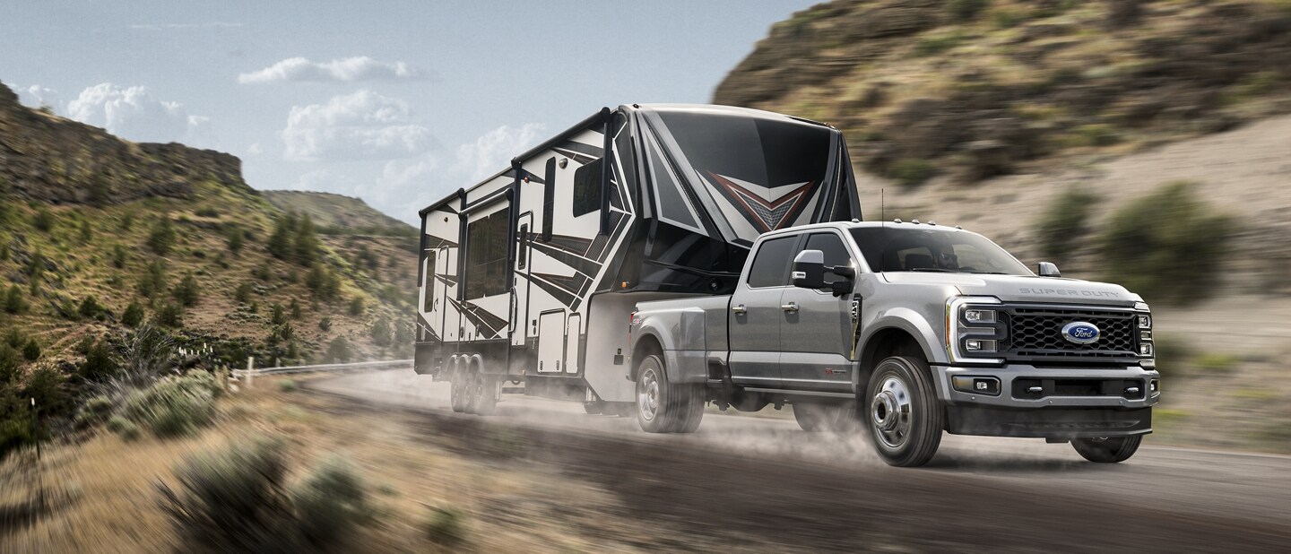 A 2023 Ford Super Duty® F-450® Limited pulling a camper on a scenic road