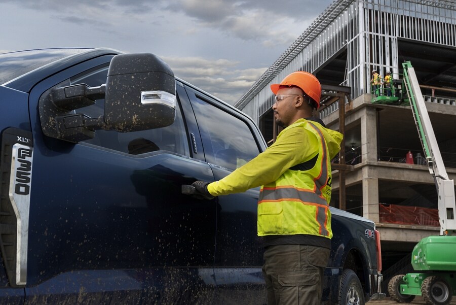 Construction worker opening the door of a 2023 Ford Super Duty® F-350 with XLT