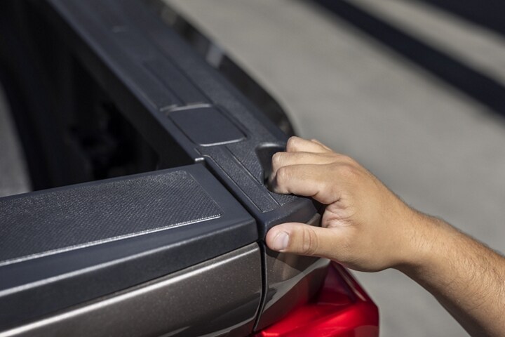 Close-up on a person grasping the truck bed hand pocket