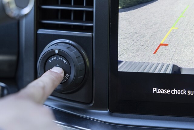 Close-up of a person pushing the pro trailer hitch assist button