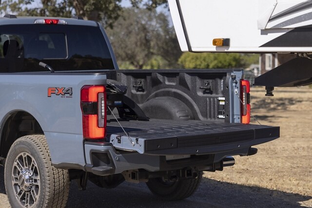 The tailgate down of a 2023 Ford Super Duty® truck being backed up to a 5th-wheel camper