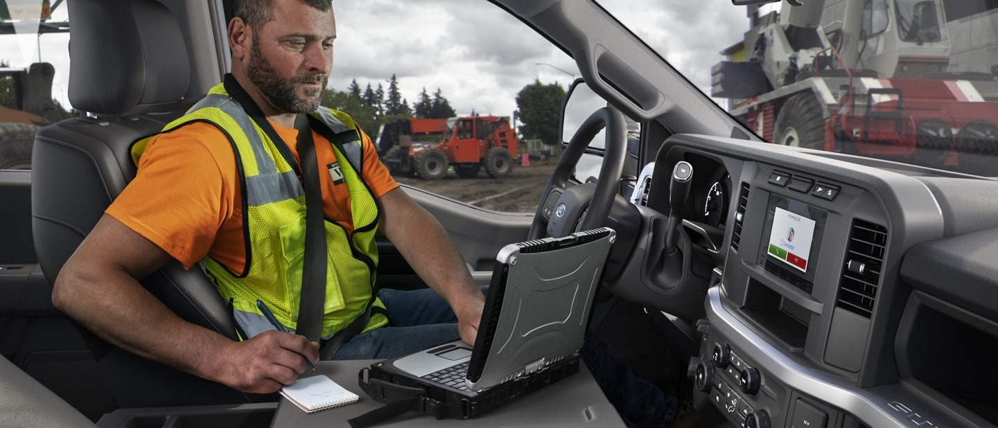 Man working on a laptop computer inside a 2025 Ford Super Duty® pickup