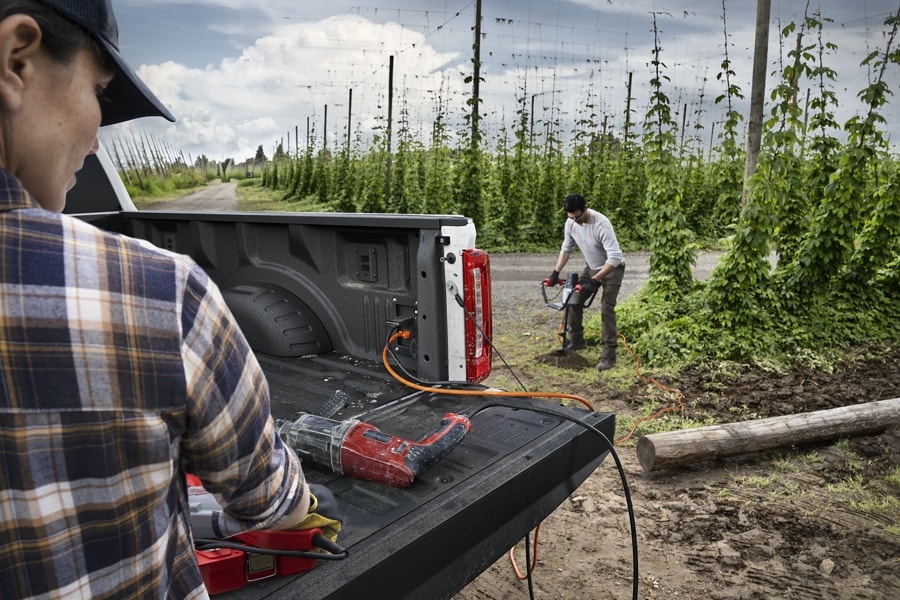 Two people using power tools plugged into the Pro Power Onboard feature