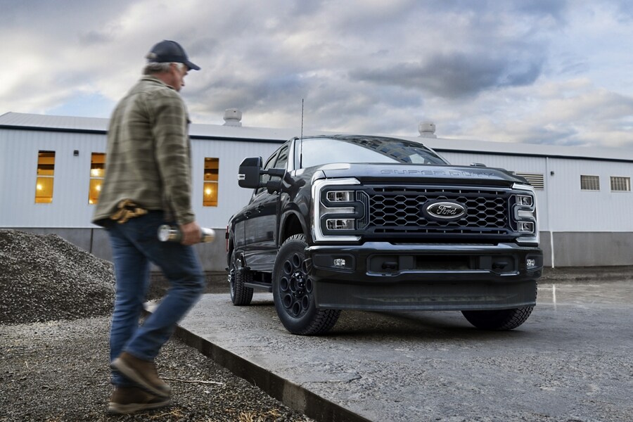 Man walking near a 2025 Ford Super Duty® LARIAT® with the Black Appearance Package