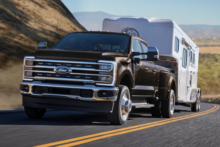 2025 Ford Super Duty® F-350® LARIAT® model in Darkened Bronze Metallic pulling a horse trailer