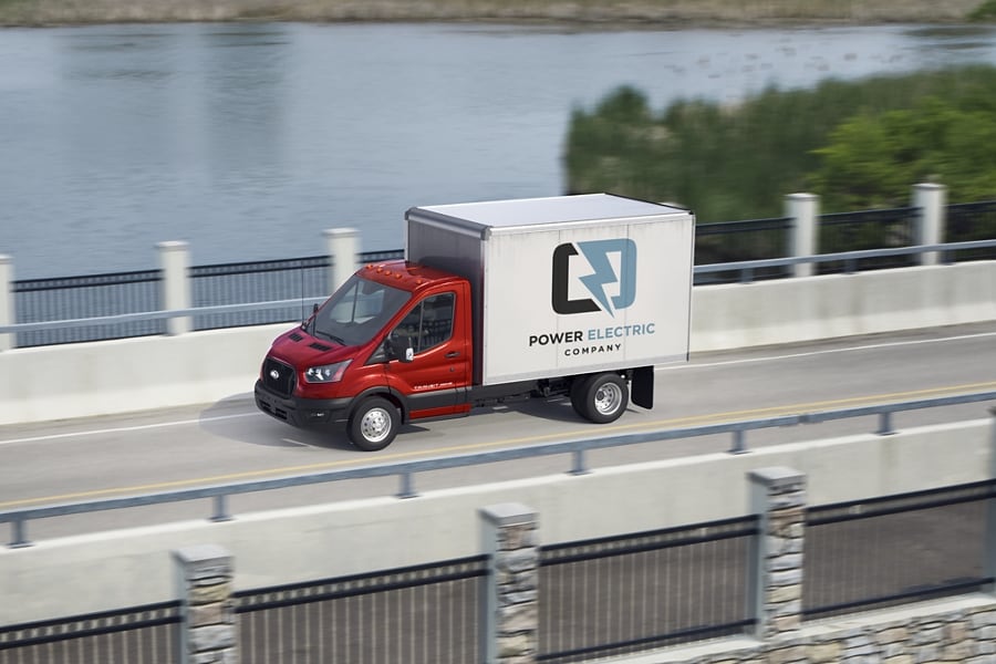 A 2022 Ford Transit Chassis Cab driving across a bridge