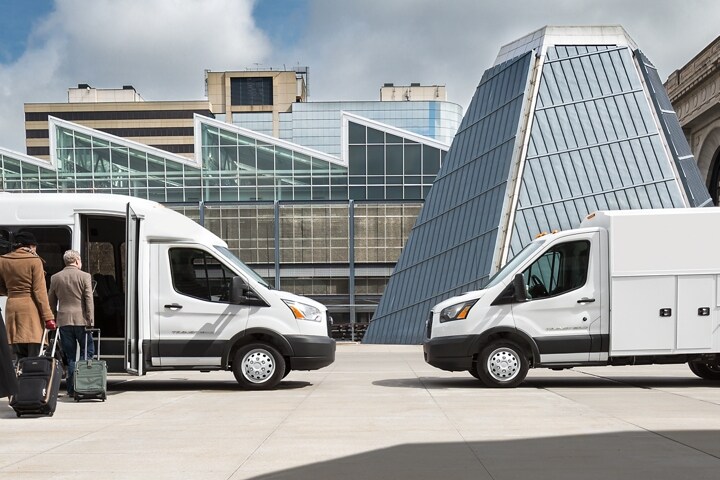 People with luggage entering a 2023 Ford Transit® Van with Shuttle Bus Prep Package parked facing a 2023 Ford Transit® Van