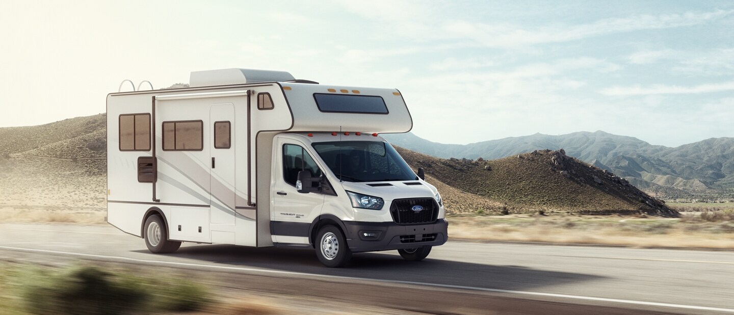 A 2023 Ford Transit® Cutaway equipped with aftermarket Class C motorhome being driven on a desert highway