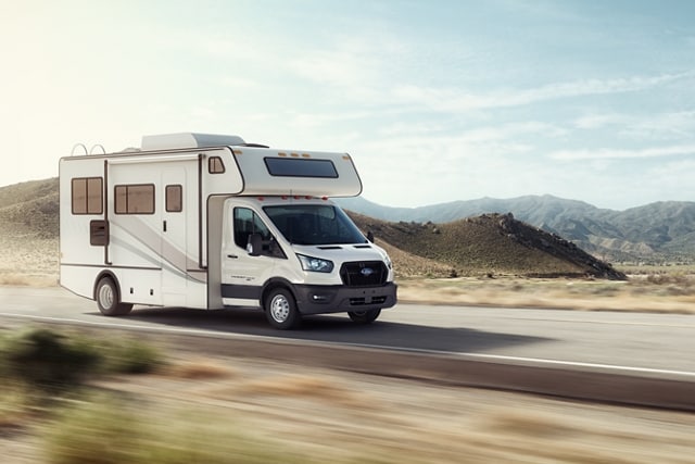 A 2023 Ford Transit® Cutaway equipped with aftermarket Class C motorhome being driven on a desert highway