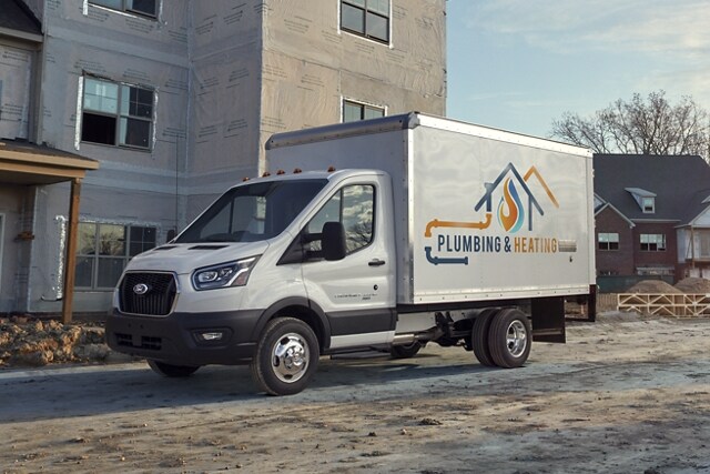 A 2023 Ford Transit® Chassis Cab parked at a house being built