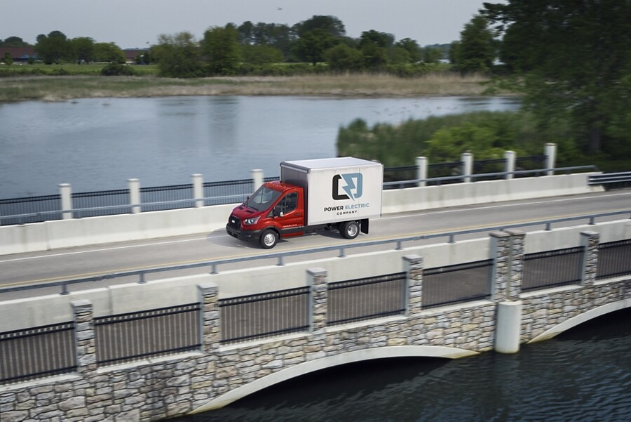 2023 Ford Transit® Chassis Cab driving over a bridge with a lake in the background