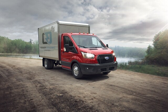 A 2023 Ford Transit® Chassis Cab on a dirt road near a lake