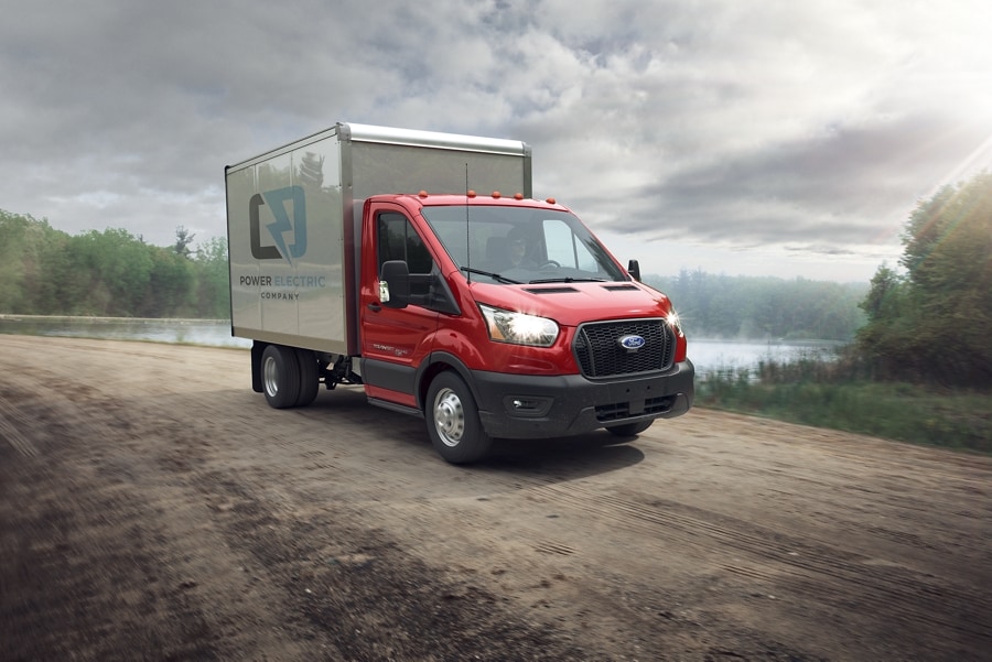 A 2023 Ford Transit® Chassis Cab on a dirt road near a lake