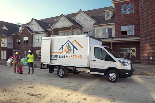 2024 Ford Transit® Chassis Cab model with box truck upfit parked at a job site with workers nearby