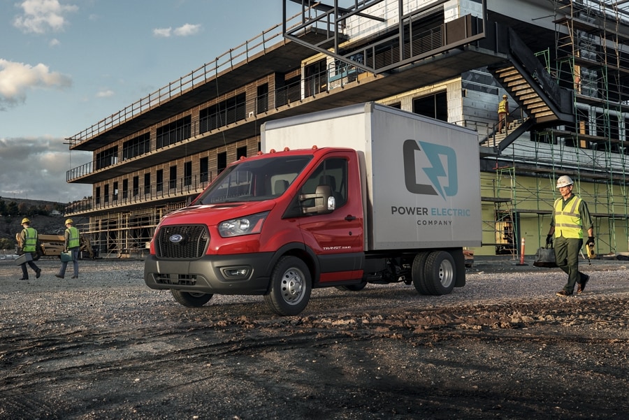 2025 Ford Transit® Chassis Cab with box truck upfit parked at a construction site with a person approaching in safety gear