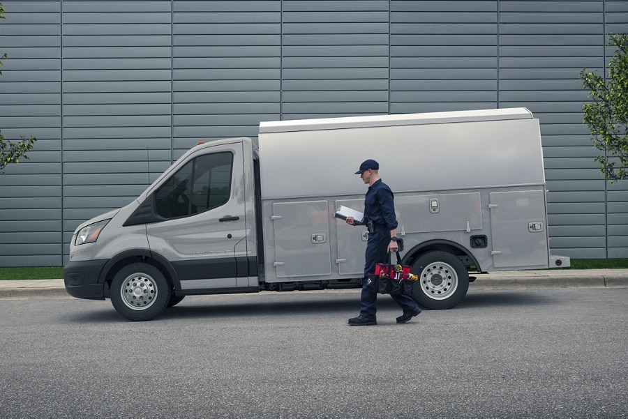 A person approaching a 2025 Ford Transit® Chassis Cab model with mechanic's truck upfit