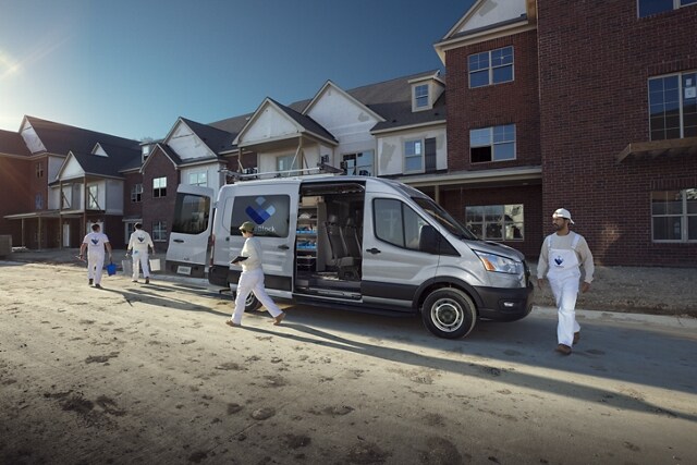 A work crew walking away from a 2023 Ford Transit® Van at a construction site