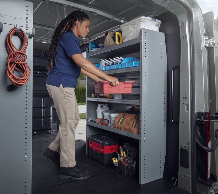A person in the back of a 2023 Ford Transit® Van with open cargo doors