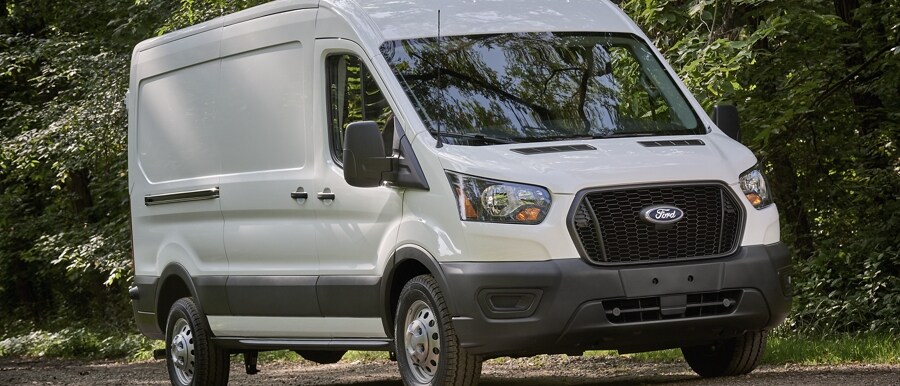 2023 Ford Transit® driving on a dirt road under shady trees