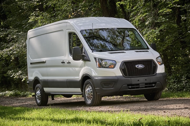2023 Ford Transit® driving on a dirt road under shady trees