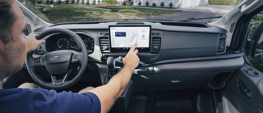 Driver using touchscreen in 2023 Ford Transit® Van featuring SYNC® Connected Navigation