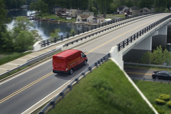 A 2024 Ford Transit® van being driven over a bridge