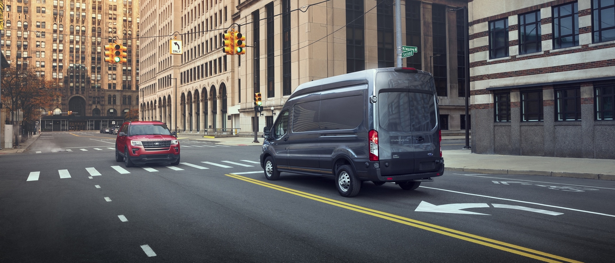 A 2024 Ford Transit® van stopped in the left-hand turn lane of an intersection