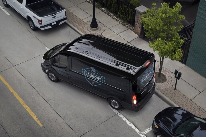 A 2024 Ford Transit® van backing into a parking space