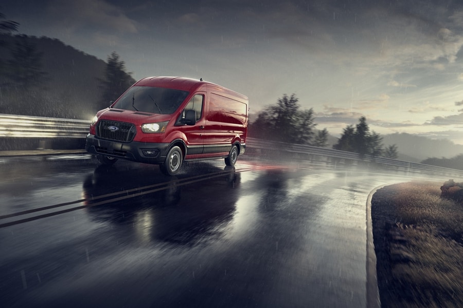A 2025 Ford Transit® van being driven on a wet curvy road